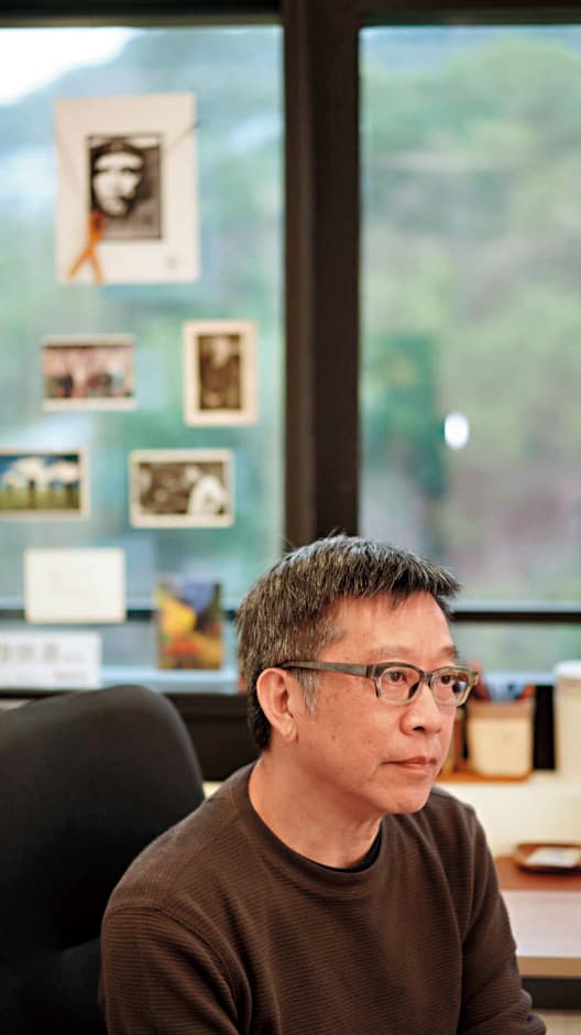 位於城市大學的辦公室裡,趙崇基刻意在窗玻璃上貼了雨傘運動的海報及古巴革命家切格瓦拉的照片。(趙崇基提供)
