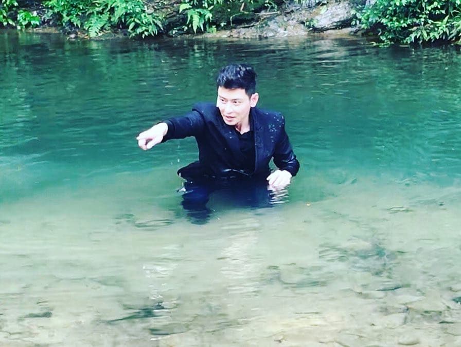 陳冠霖在臉書PO出一張身穿西裝在河裡的拍戲花絮照,引起網友猜測應該是李燕墜河失蹤。(翻攝陳冠霖牛仔部落格臉書)