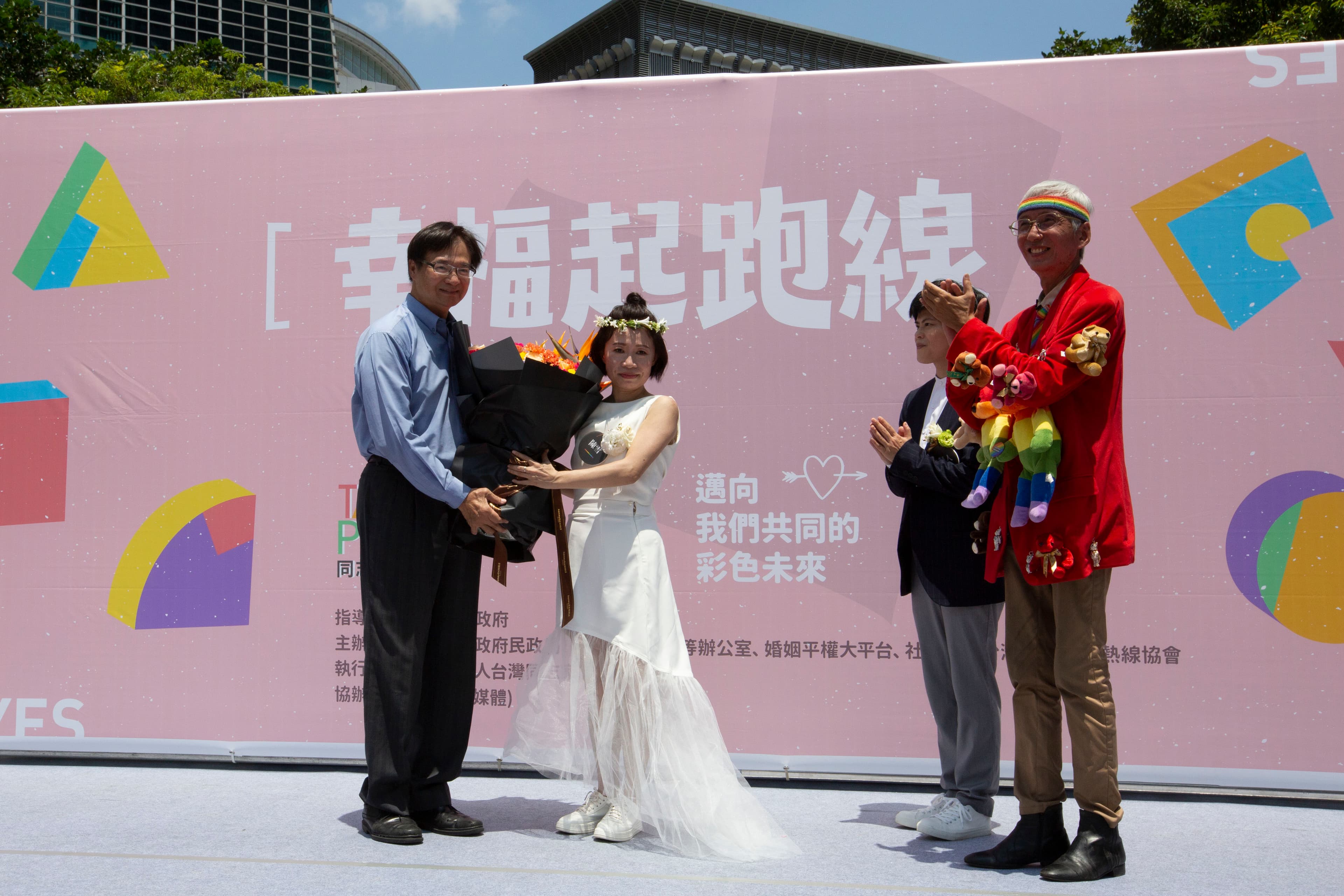 作家陳雪(左二)與伴侶早餐人(右二)辦理結婚登記,北市由民政局長藍世聰(左一)送花祝賀