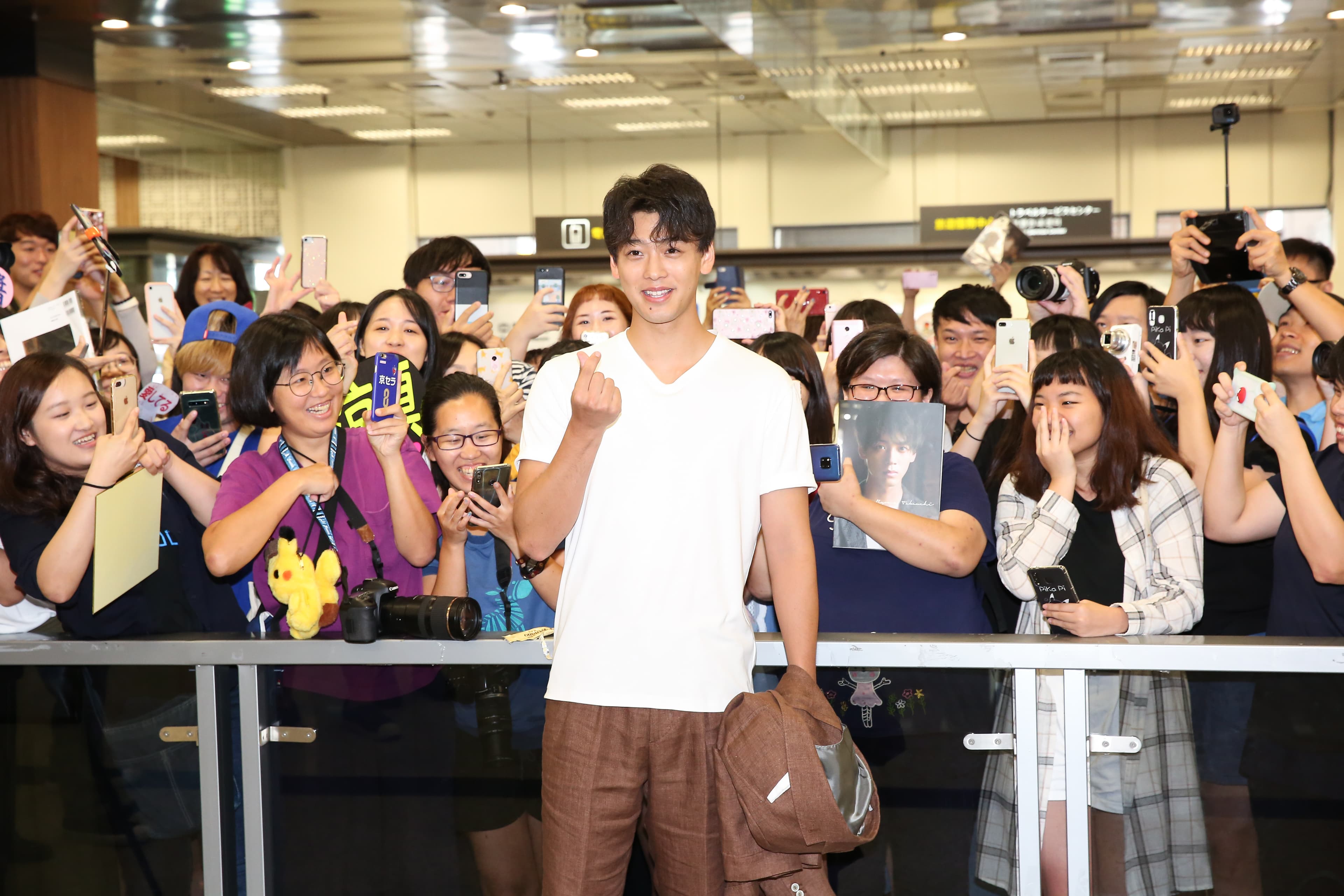 竹內涼真今(8日)抵達松山機場,受到上百位粉絲歡迎,開心合照。