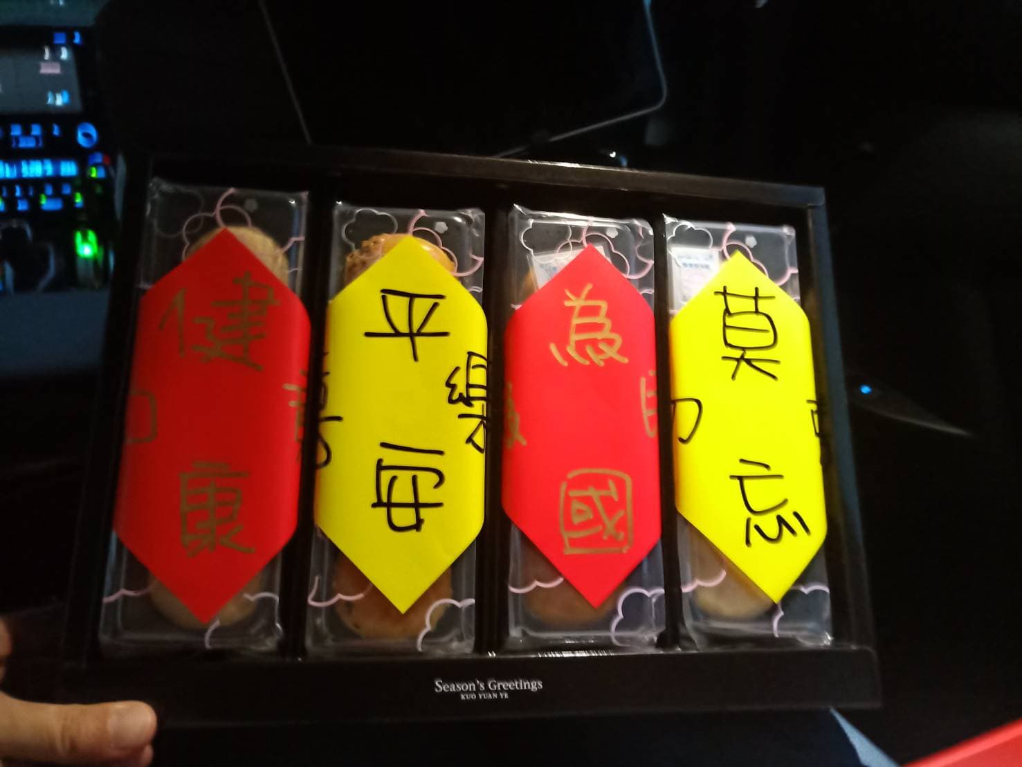 月餅上頭分別貼了紅色、黃色的紙條,分別寫著「健康如意、平安喜樂、為國為民、莫忘初衷」。(郭台銘辦公室提供)