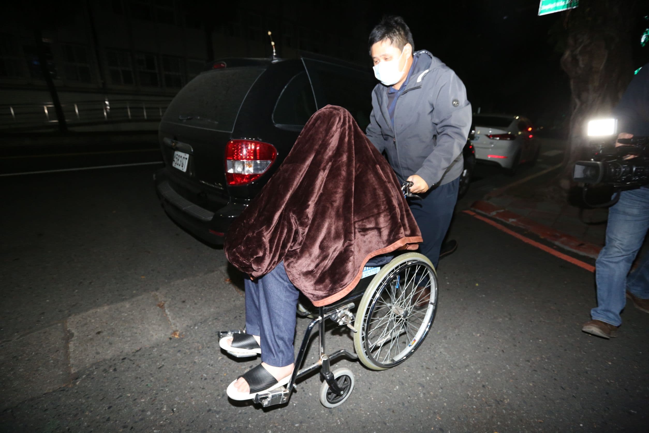 騙扁小子黃琪(前)涉嫌向中衛詐口罩,遭聲押禁見,坐在輪椅用毯子蓋住頭。