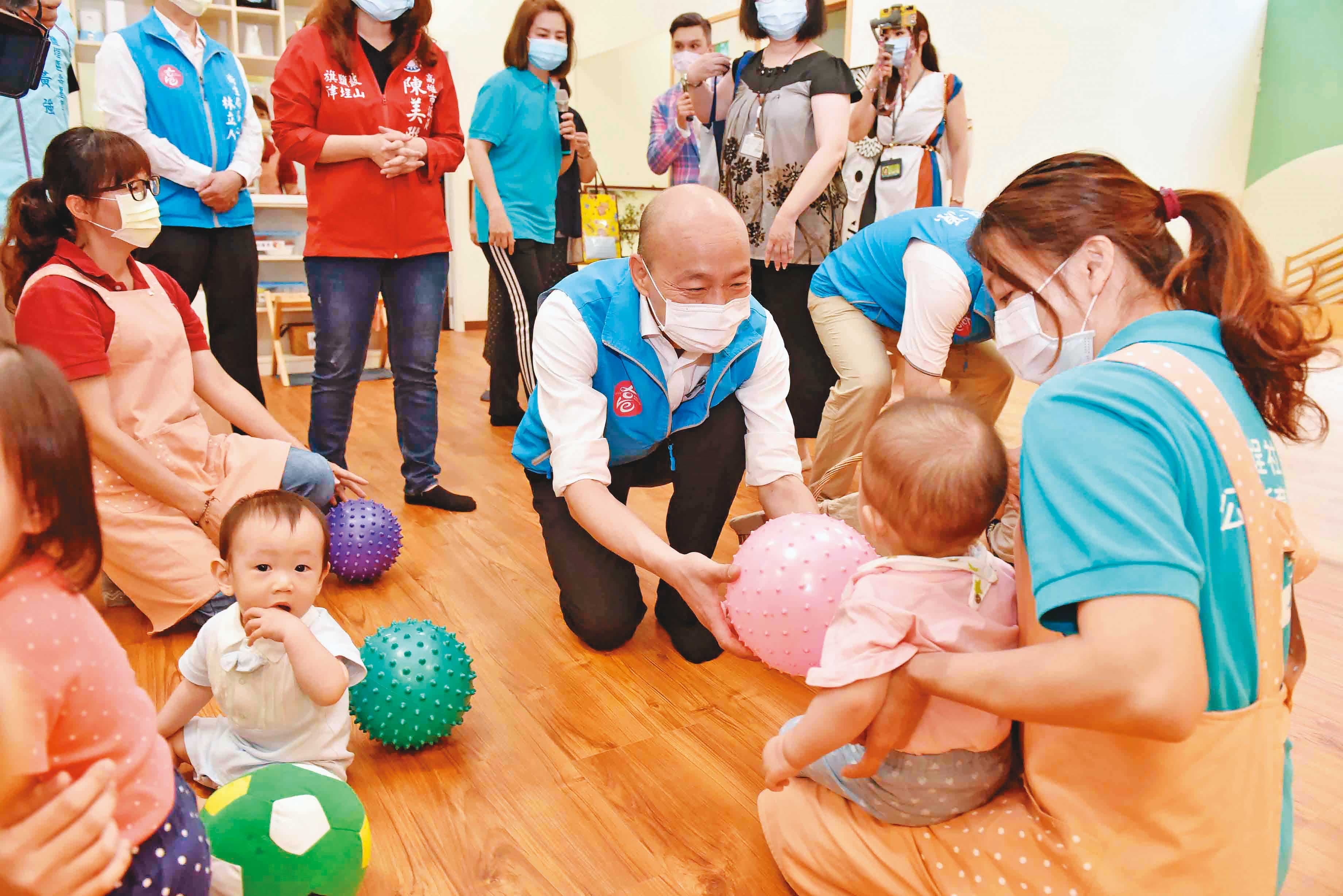 低調避戰的韓國瑜28日赴鹽埕公共托育家園揭牌、親近孩童,並開出7月提高托育人員薪資的承諾。(高雄市政府提供)