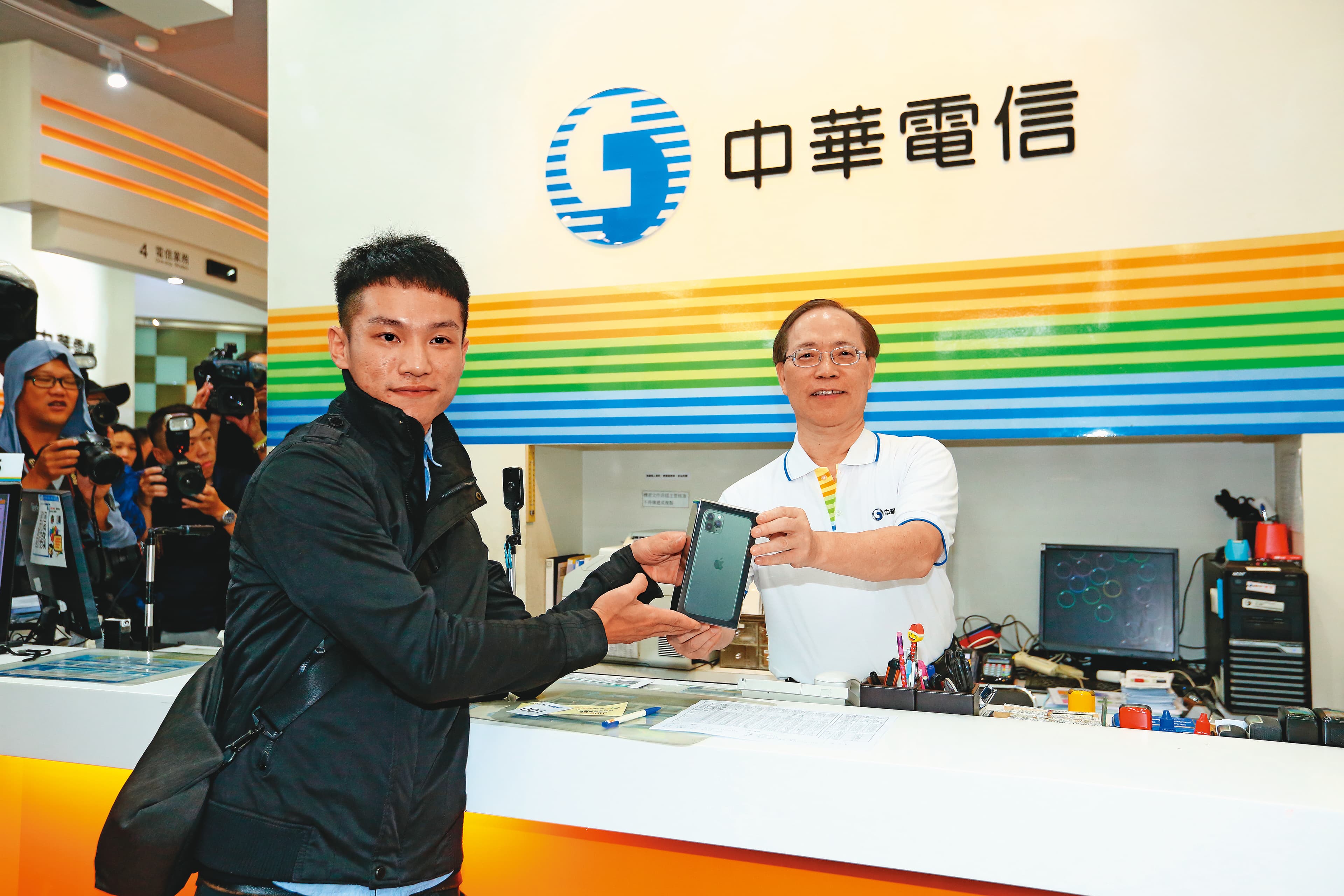 去年果粉排隊140小時,謝繼茂(右)化身1日店長,售出中華電信首支iPhone 11手機。