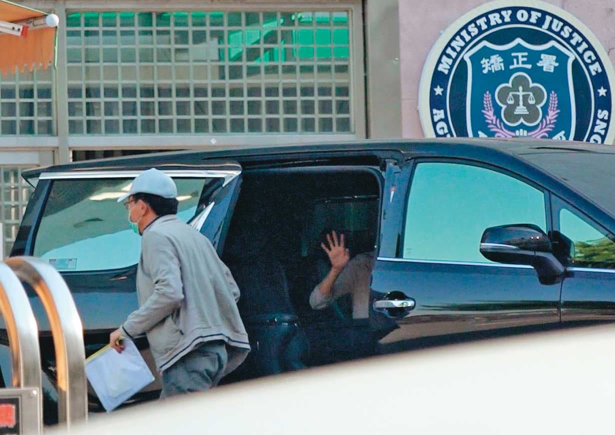 高志鵬一身鴨舌帽、口罩準時返回八德外役監,女友一路隨車相伴,還離情依依揮手向他道別。