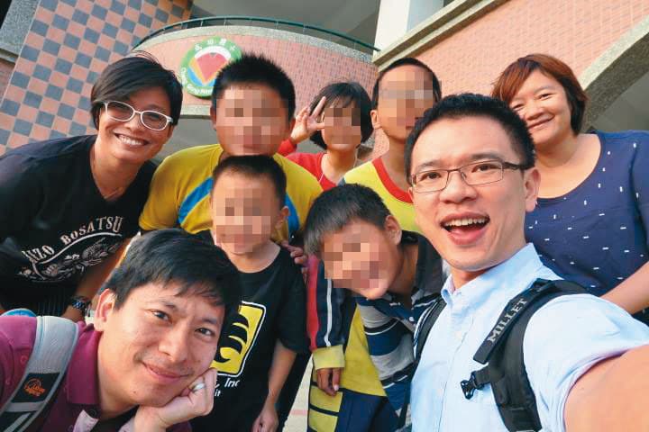 演講完,鄭智偉(前排右1)和同學、老師合照。他說,自己總在同學面前出櫃,「我希望讓同學看到,有一個活生生的人是同性戀,那你以後開玩笑要罵人『死gay』的時候,會有一點難開口說出來。」(鄭智偉提供)