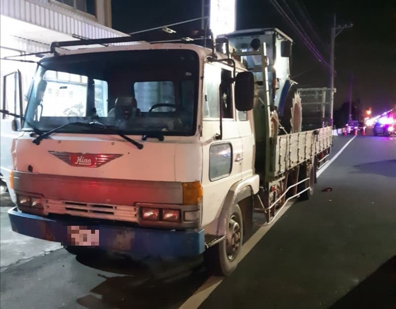 女警擦撞到違規停車的拖板車駕駛,倒地後遭後方來車輾斃。(翻攝畫面)