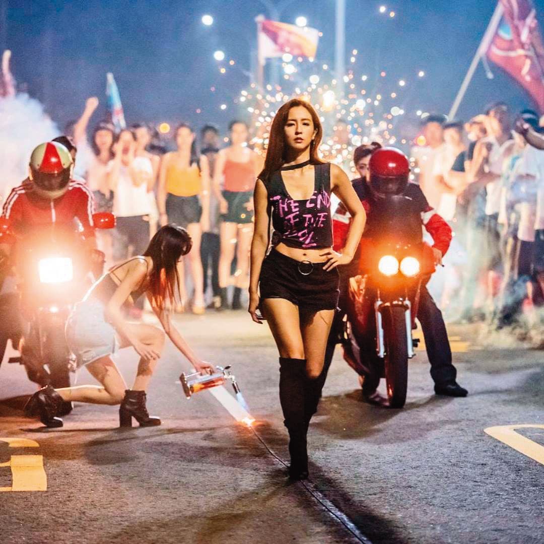 喜歡演戲的藍甯(左二)曾客串演出電影《鬥魚》,在周曉涵(前)身後點火,但戲分不多,僅有幾秒畫面。(翻攝自藍甯臉書)