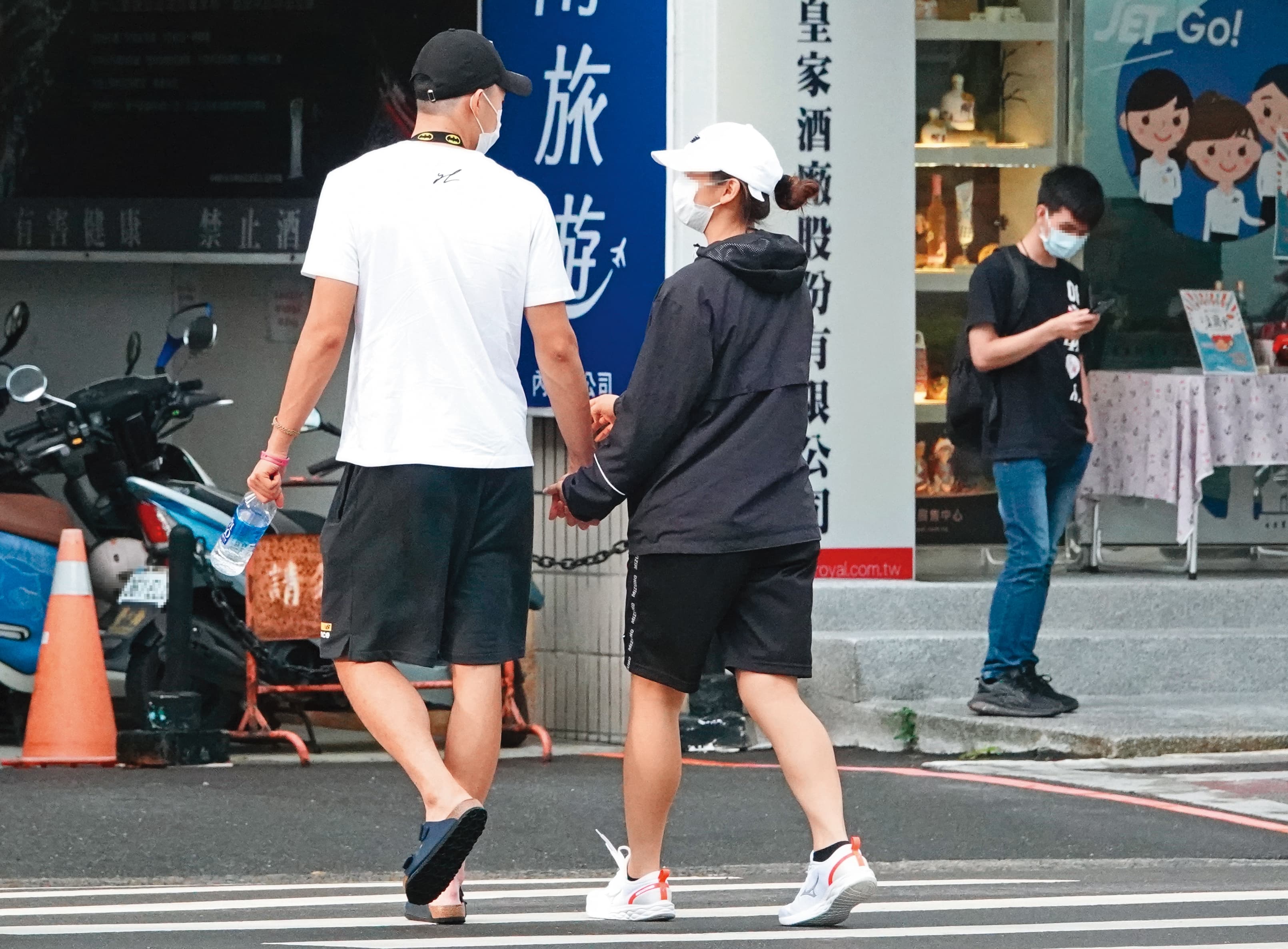 16:59,過馬路時,王齊麟緊緊牽住女友的手,可見小別勝新婚。