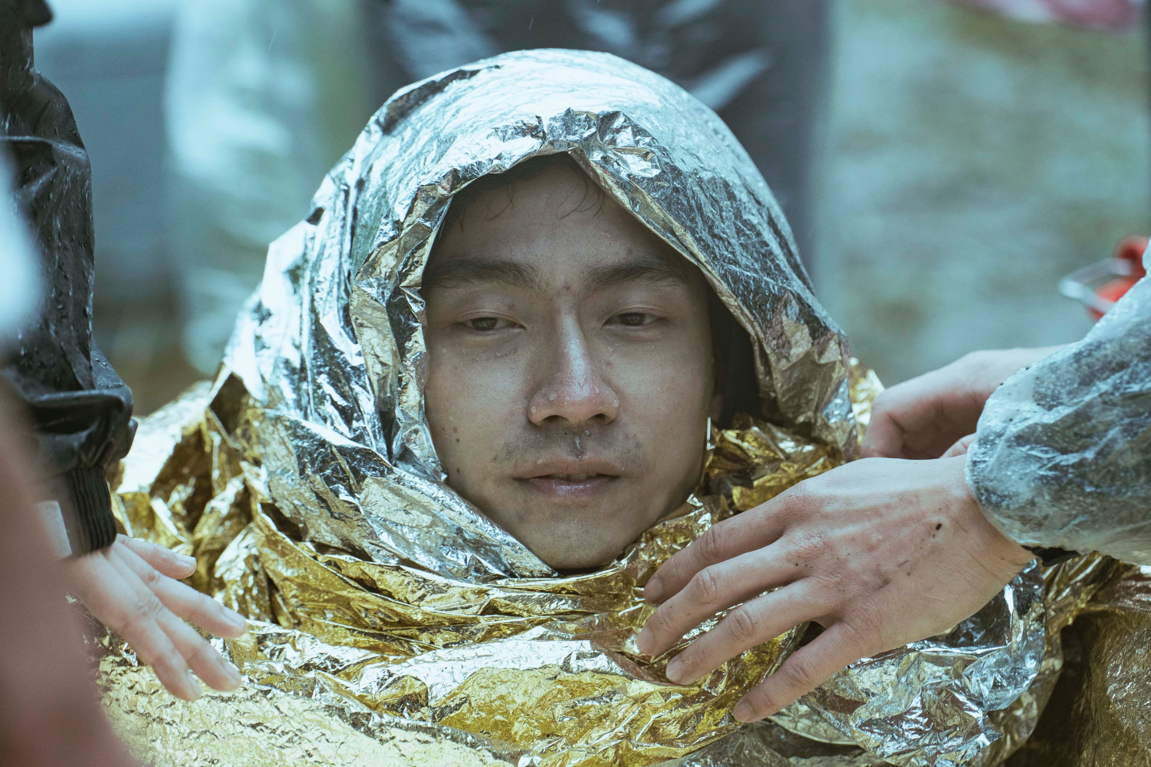 大鶴拍戲從水中上來時,渾身發抖,工作人員立即協助讓他恢復溫暖。(金盞花大影業提供)
