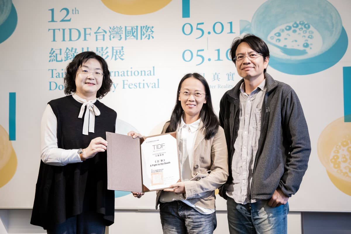 謝欣志(右起)與陳芝安2020年以《力爭》入圍台灣國際紀錄片影展台灣競賽單元,由文化部影視局局長徐宜君(左)頒發證書。 (TIDF提供)