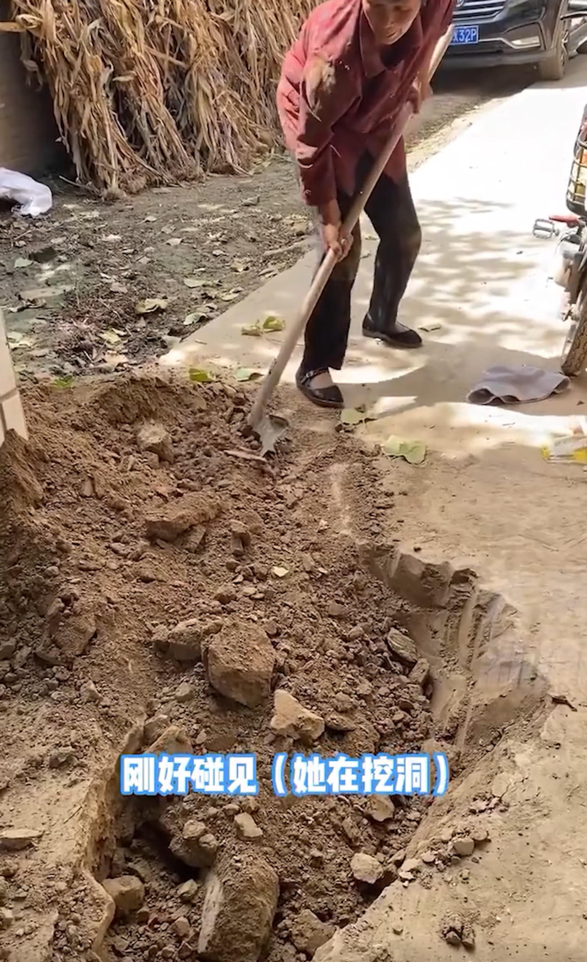 老婦人拿鐵鏟在家門前挖土。(翻攝微博)