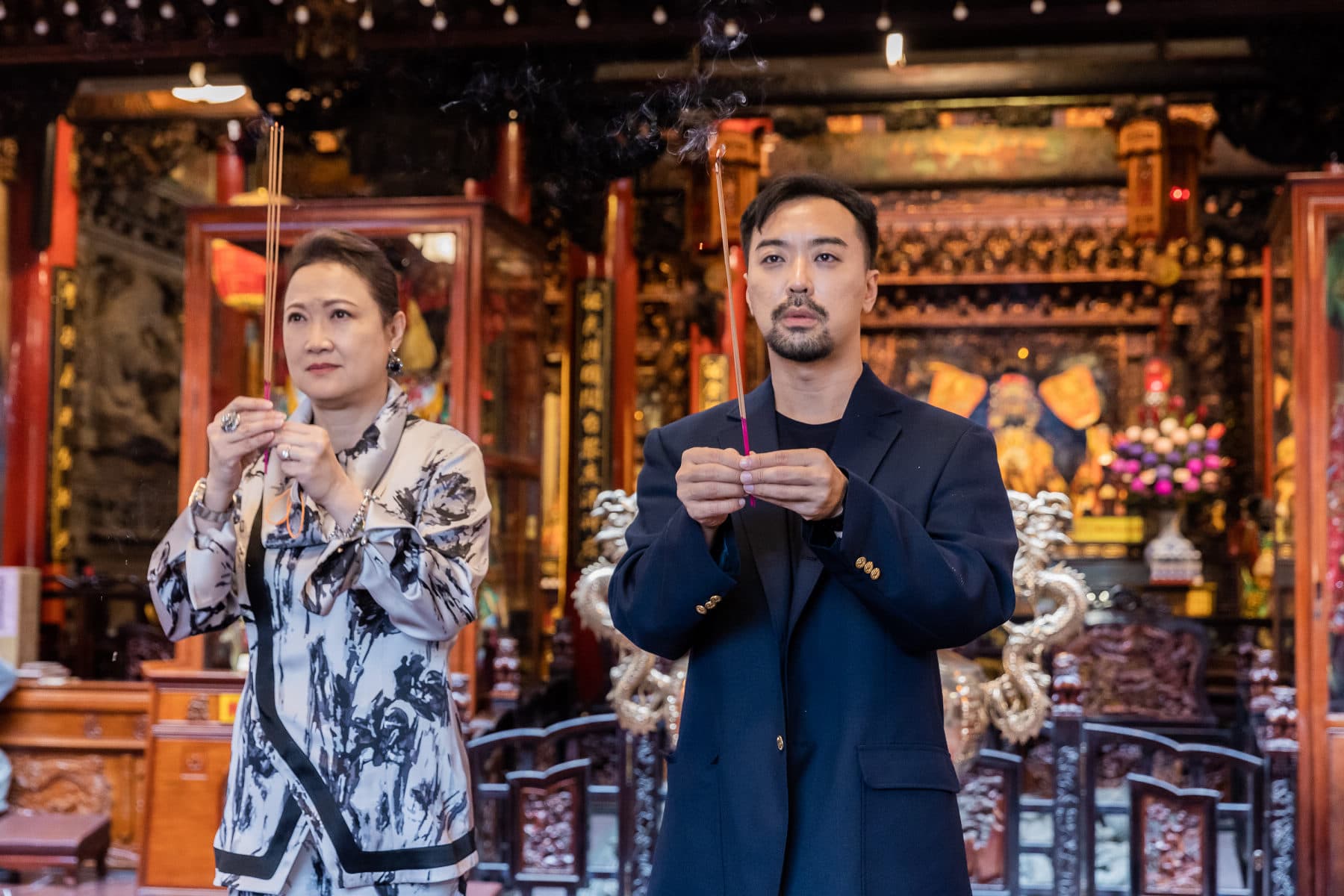 為求電影在台上映順利,何書銘(右)及洪慧芳虔誠捻香祈求媽祖降好運。(采昌)