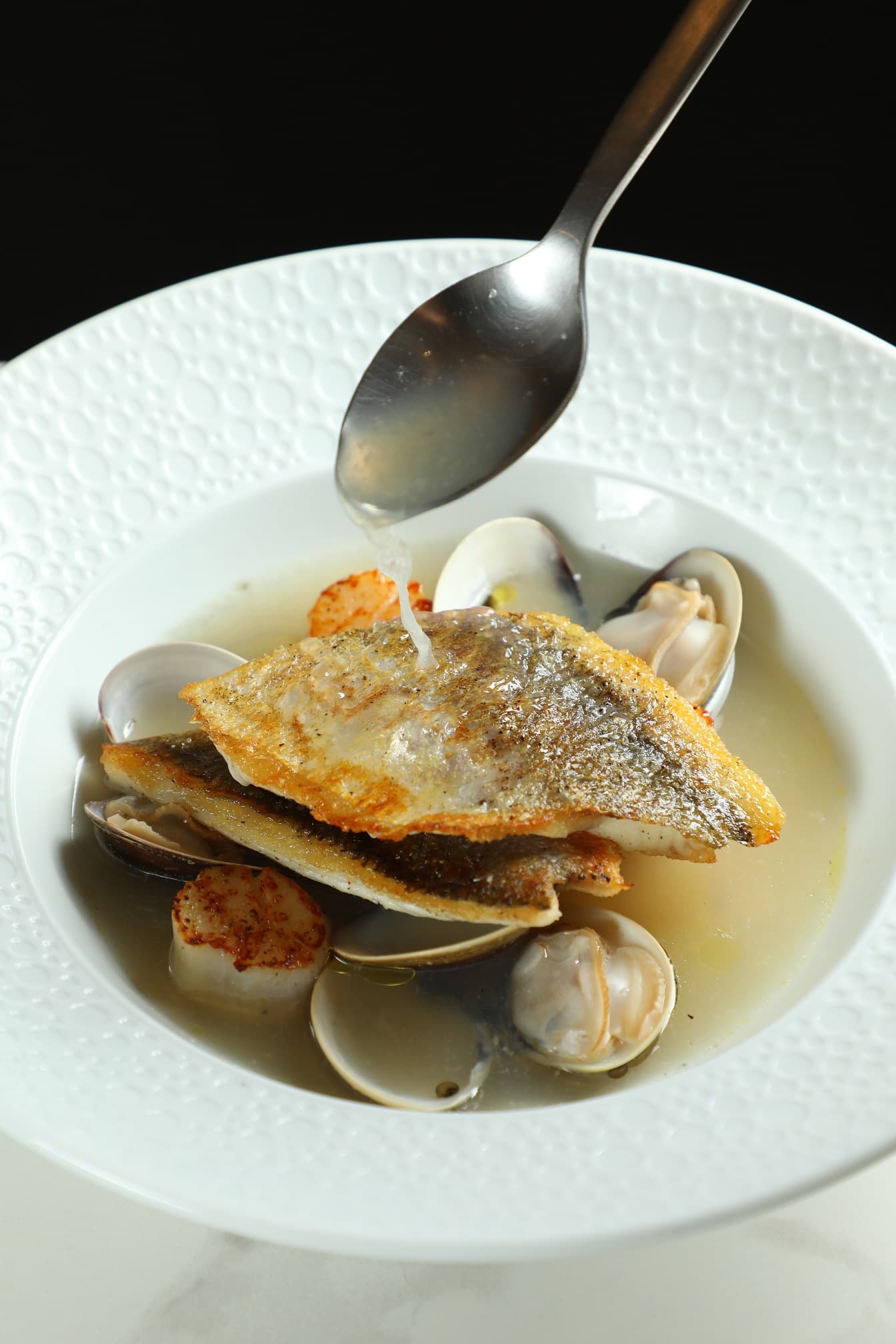 「季節鮮魚」以乳清加入魚湯,與干貝、蛤蠣共呈鮮美。(780元/份)