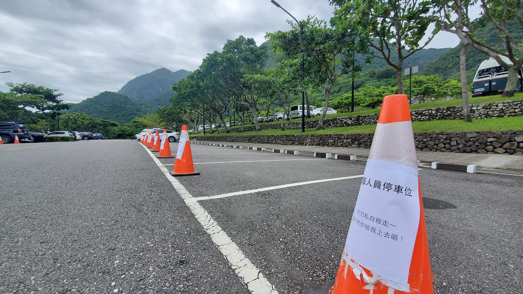 網友看到停車格上擺放一排三角錐,上頭貼著「移走就上去唱」的告示。(翻攝臉書「路上觀察學院」)