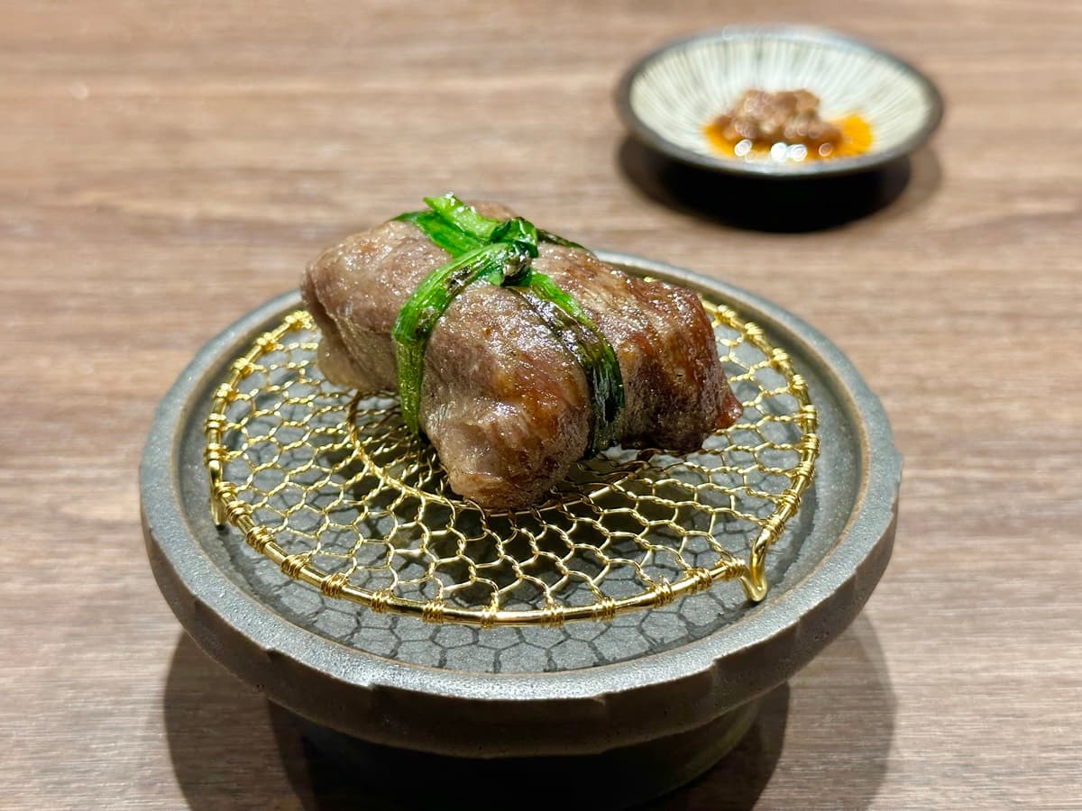 「紐約客/鹽蔥」用韭菜綁成小禮包造型,一口咬下會爆汁,油潤不鹹膩。
