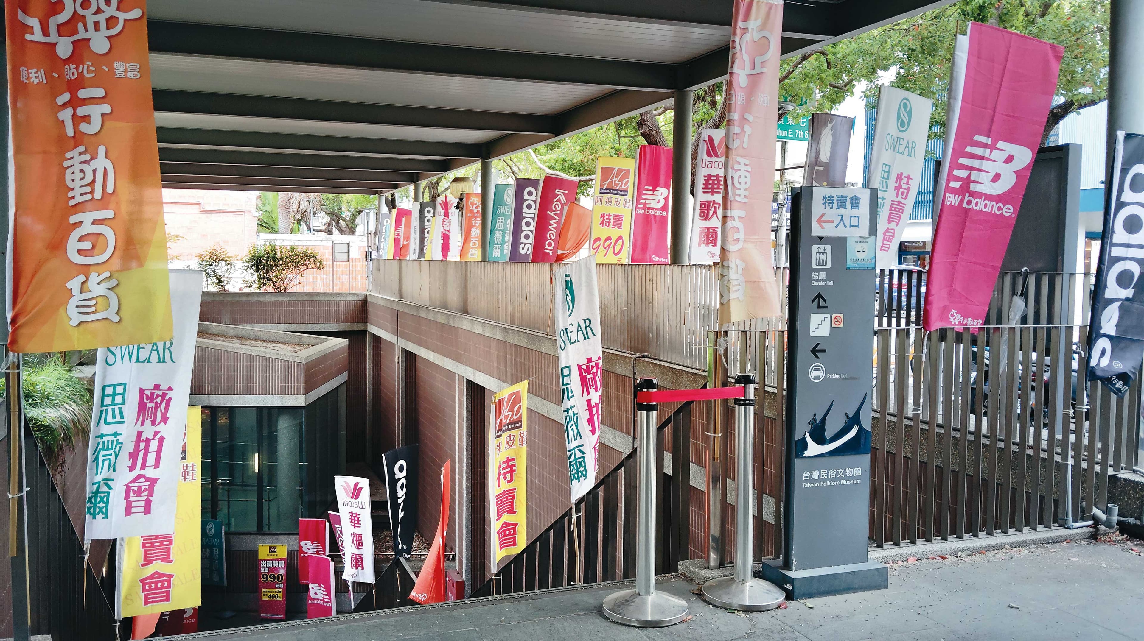 臺灣民俗文物館展區入口處插滿攤商廣告旗幟,吸引顧客上門消費。(鄧玉瑩攝)