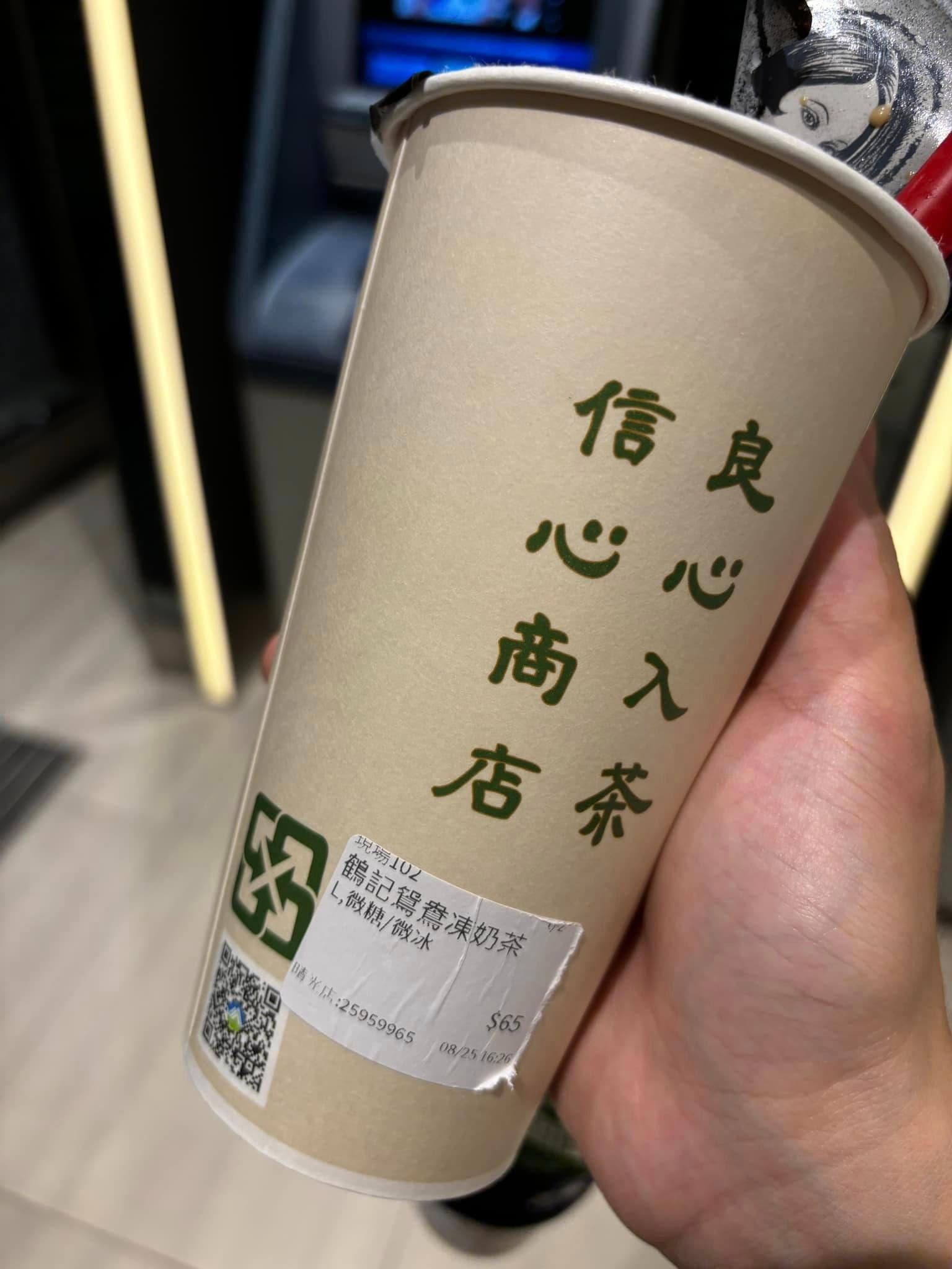 消費者在鶴茶樓飲料裡吃到爆漿蟑螂,對比杯身「信心商店,良心入茶」的標語格外諷刺。(翻攝自爆料公社)