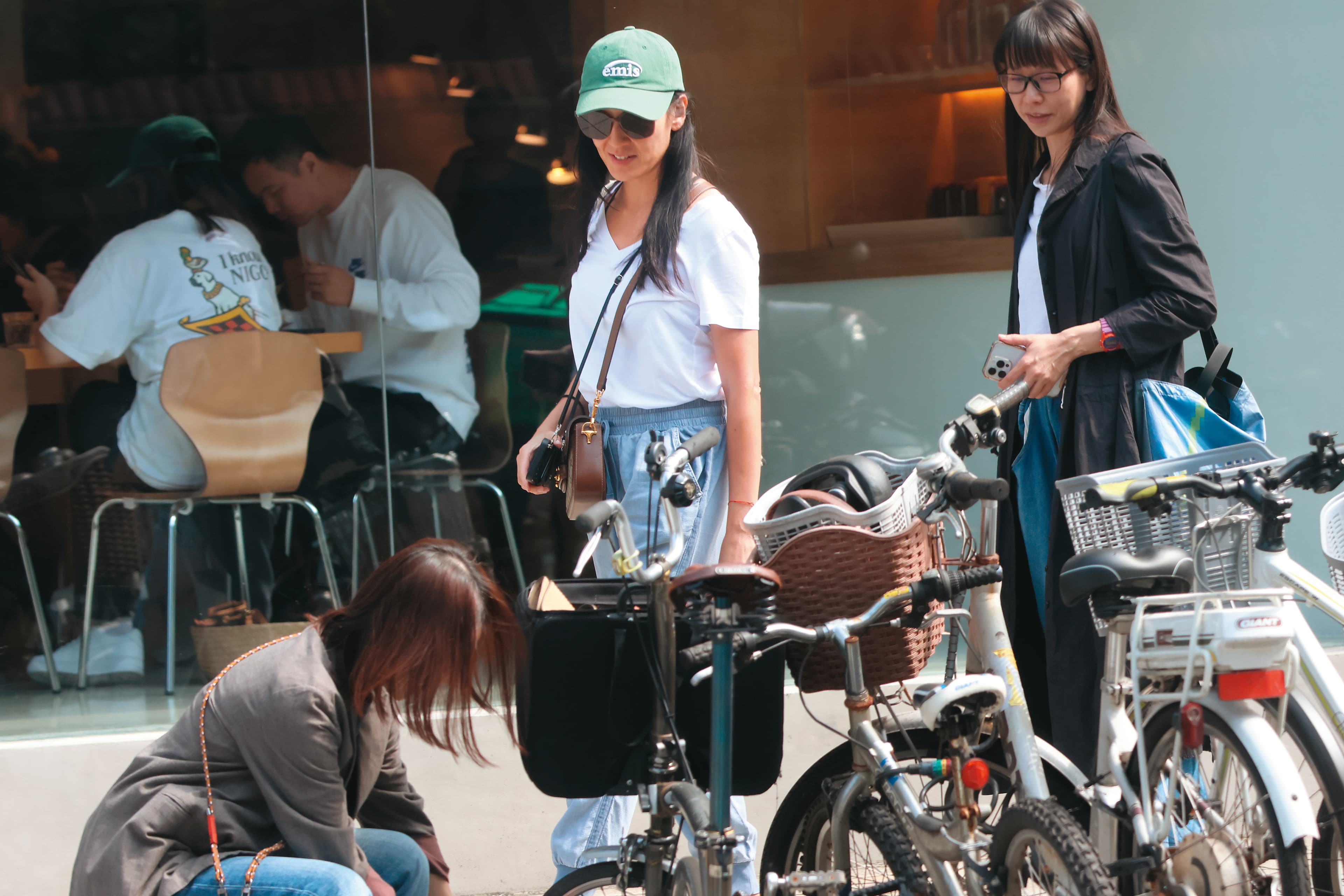 10/16,13:01,友人解鎖停放在店外的小摺(自行車),林熙蕾(中)竟看得十分投入,似乎對騎小摺出門甚有興趣。