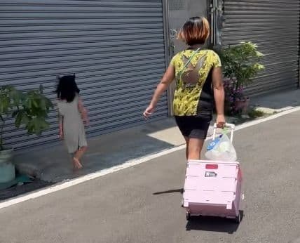 小孩子受不了疼痛,試圖躲到陰影處,卻被媽媽一把拉回太陽底下繼續踩在滾燙的柏油路上走。(翻攝自臉書社團「新竹大小事」)