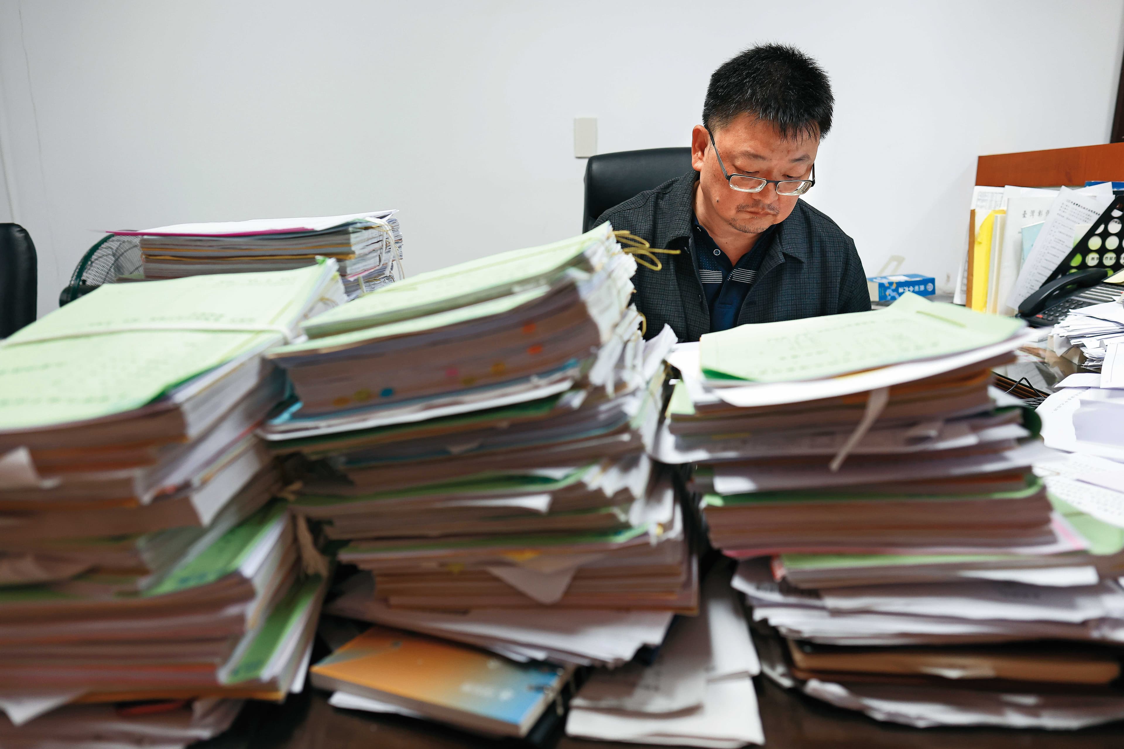鮑慧忠的桌上堆滿卷宗,他說,近年法院快要被詐騙案件淹沒。