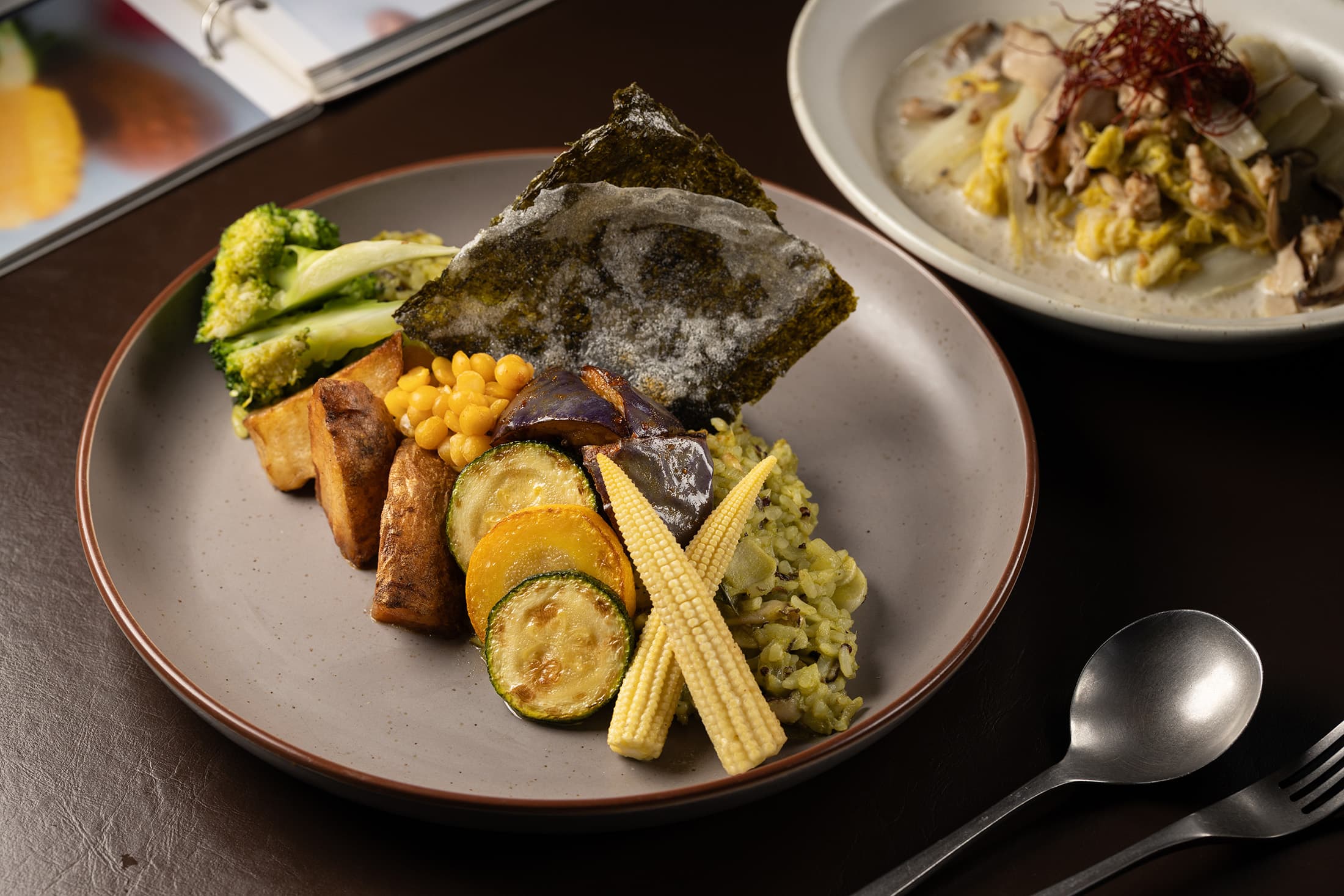「蘑菇黃扁豆綠咖哩燉飯」透過香茅、檸檬葉、青龍椒等原型食材調製出獨特的風味與顏色,米飯在煮製過程中特別講究清洗方式與軟硬度,層次豐富。(480元/份)