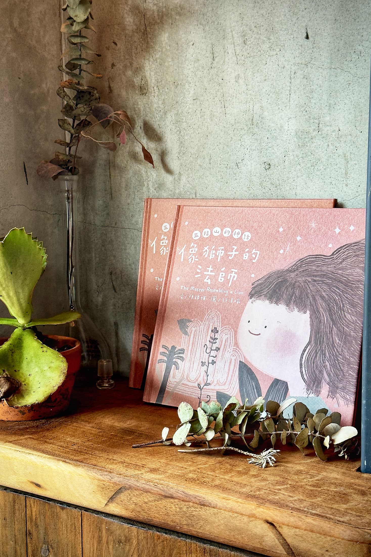 店裡除了擺設阿輝的陶藝作品、植栽布置,在書架上也能找到他與畫家一起創作的繪本。(童心怡攝)