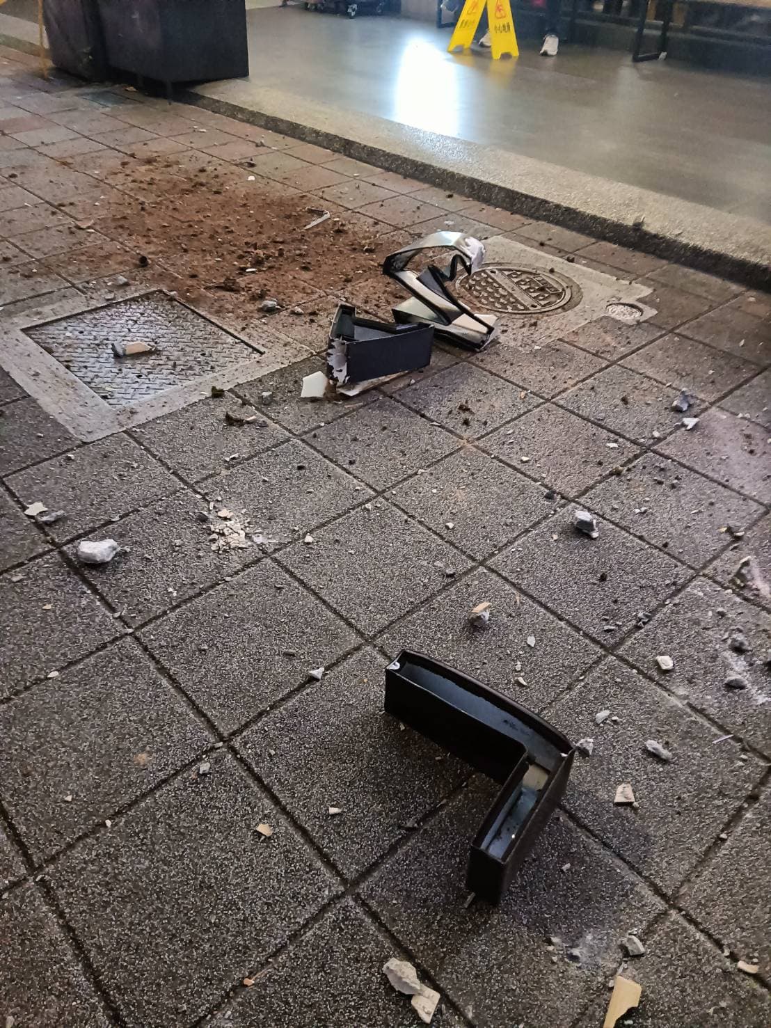 外牆磁磚脫落導致人行道上滿布大小水泥塊碎屑。(翻攝畫面)
