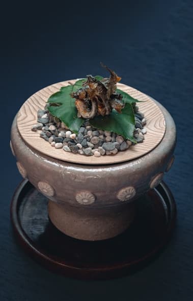 香魚烤物盛在陶甕上出場,氣勢十分驚人。(赫士盟提供)