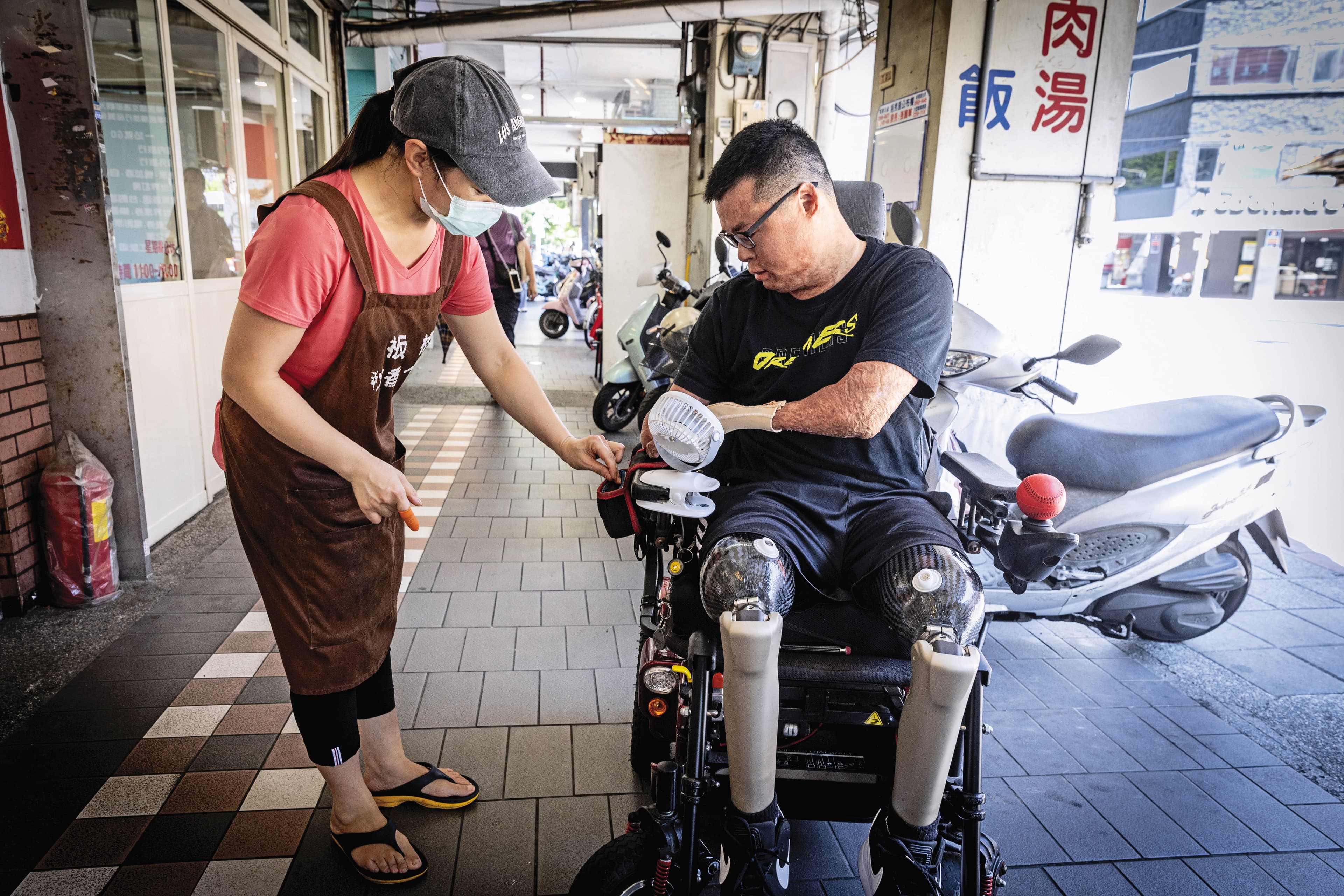 黃博煒(右)和經常光顧的小吃店家老闆(左),共同建立了付費找錢的SOP,2人談笑就像街坊好友。