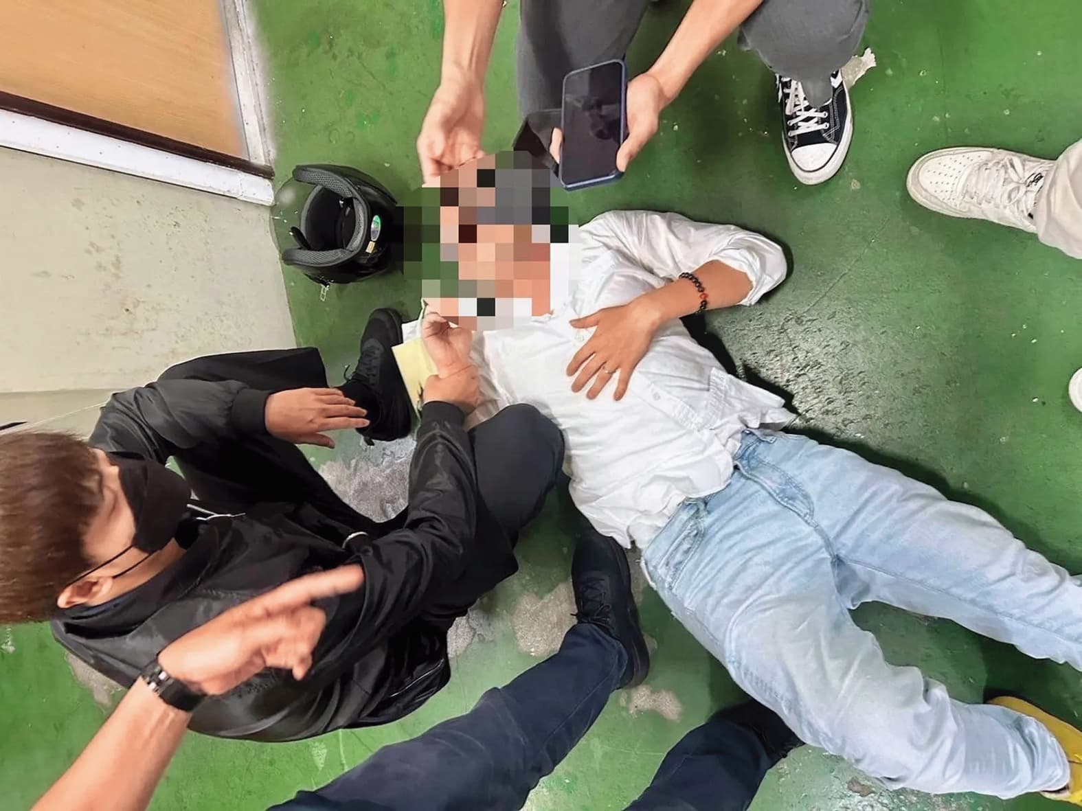 陳鑒在新北板橋火車站遭警方壓制在地,畫面狼狽。(讀者提供)