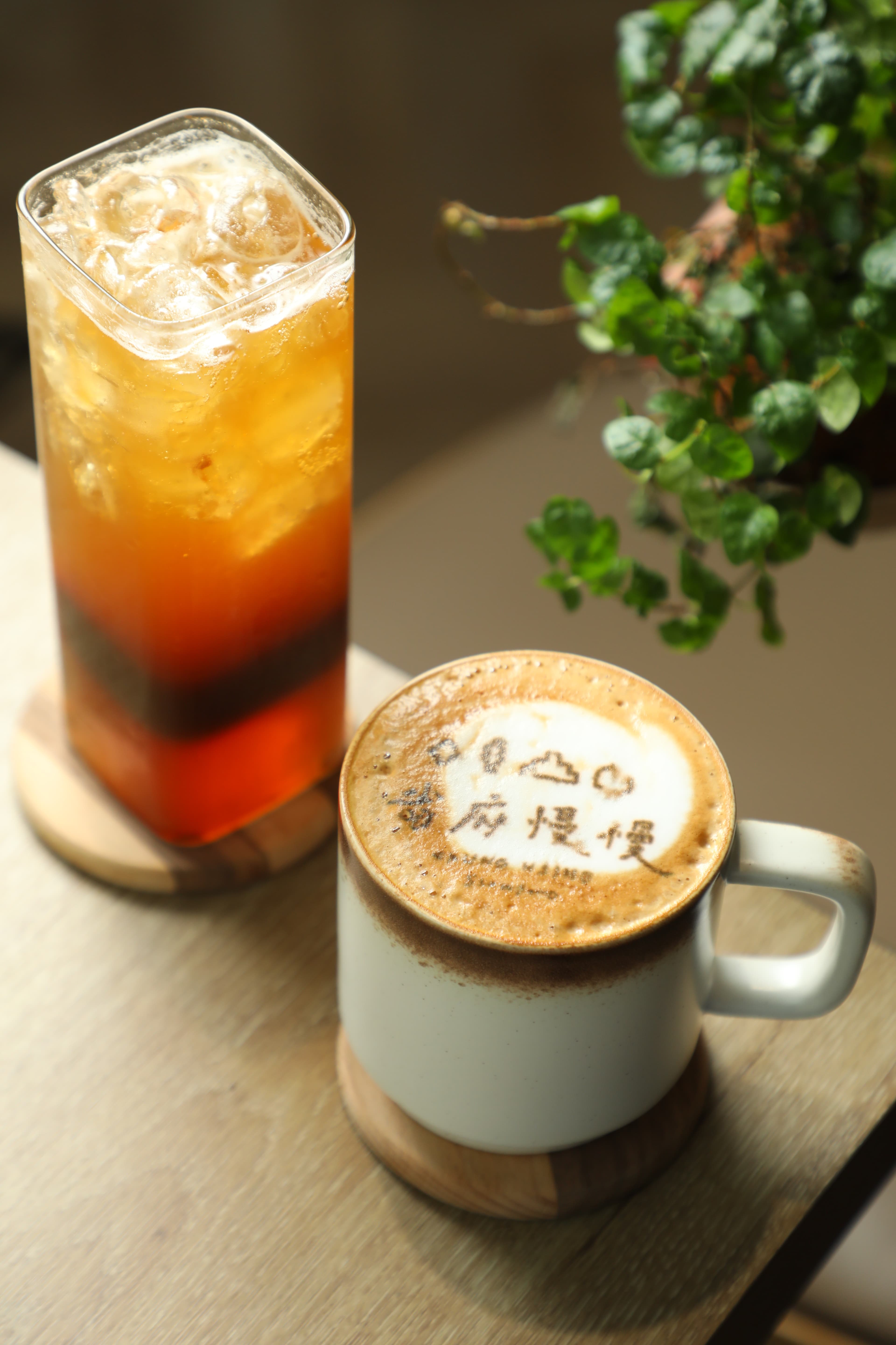 用在地小農牛奶製作的「拿鐵咖啡」(右,90元/杯)與用省府烏梅與中寮柳橙調配的「美式咖啡氣泡」(左,120元/杯)。