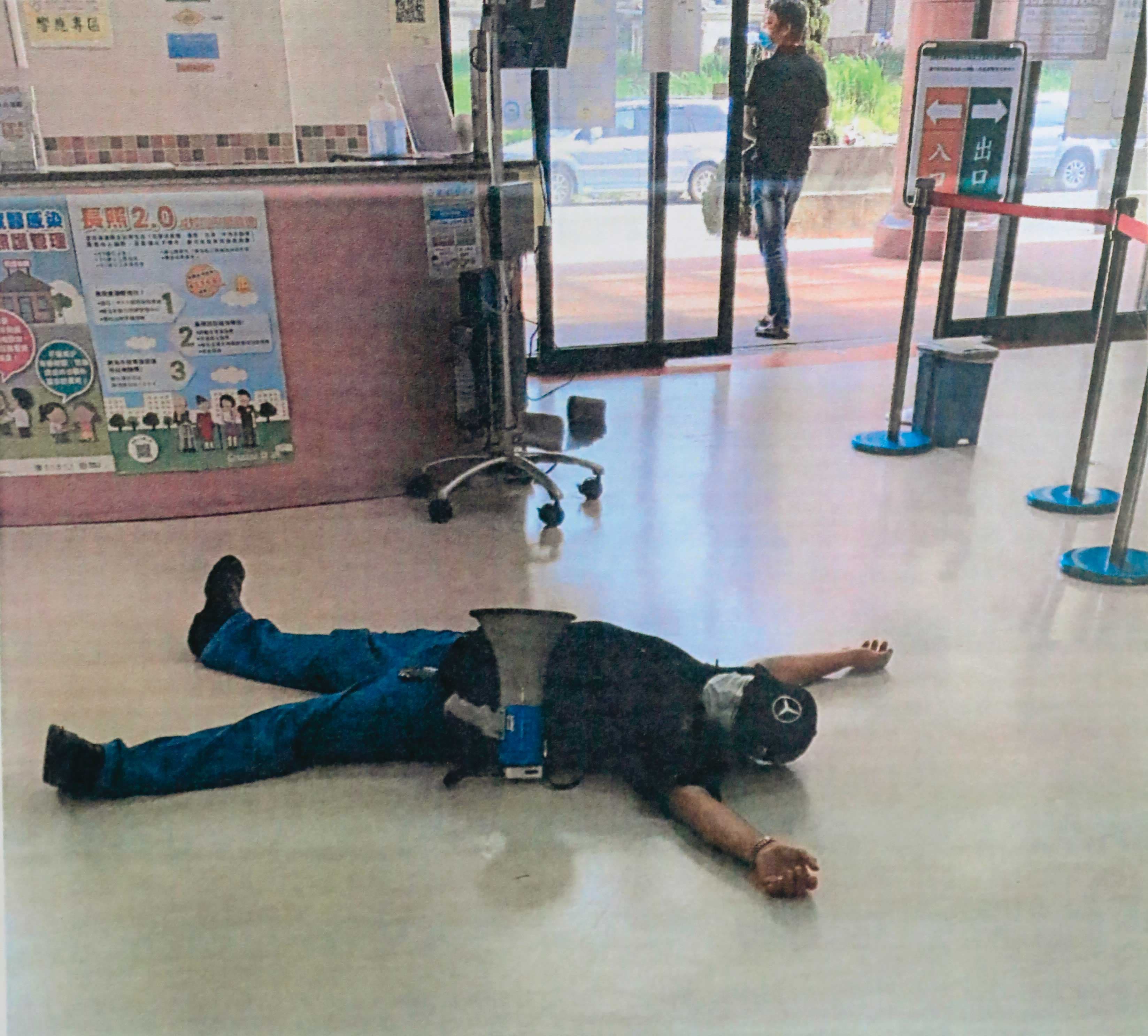 黃成德駕駛貼有字條的廂型車到懷寧醫院門口,並直接躺在地上鬧事。(讀者提供)