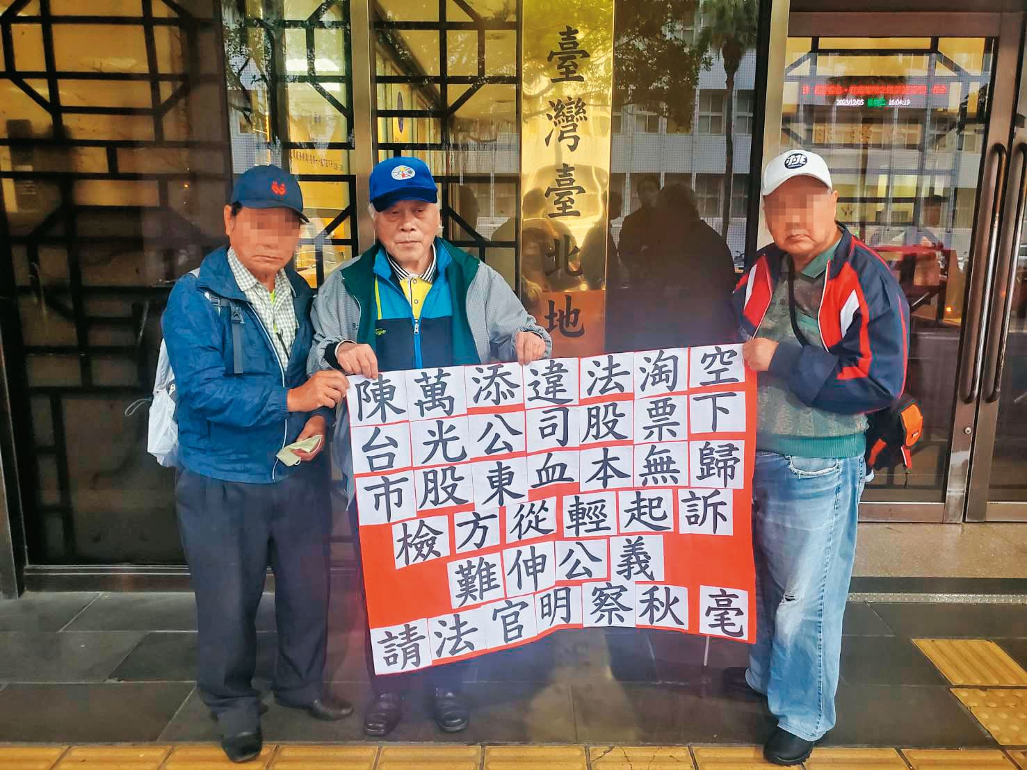 金山財神廟前董事長鄭楠興(中)與受害股東代表在法院外拉布條,籲請法官對陳萬添從重量刑。(讀者提供)