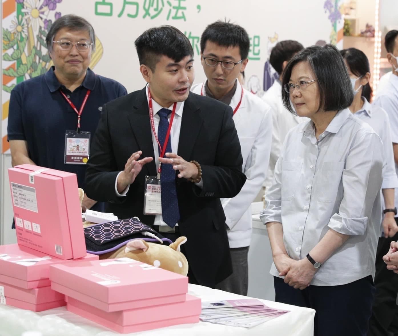 相當關注寵物長照議題的蔡英文,在寵物展上認真地聽能光能墊的用途。(寵樂動物醫院提供)