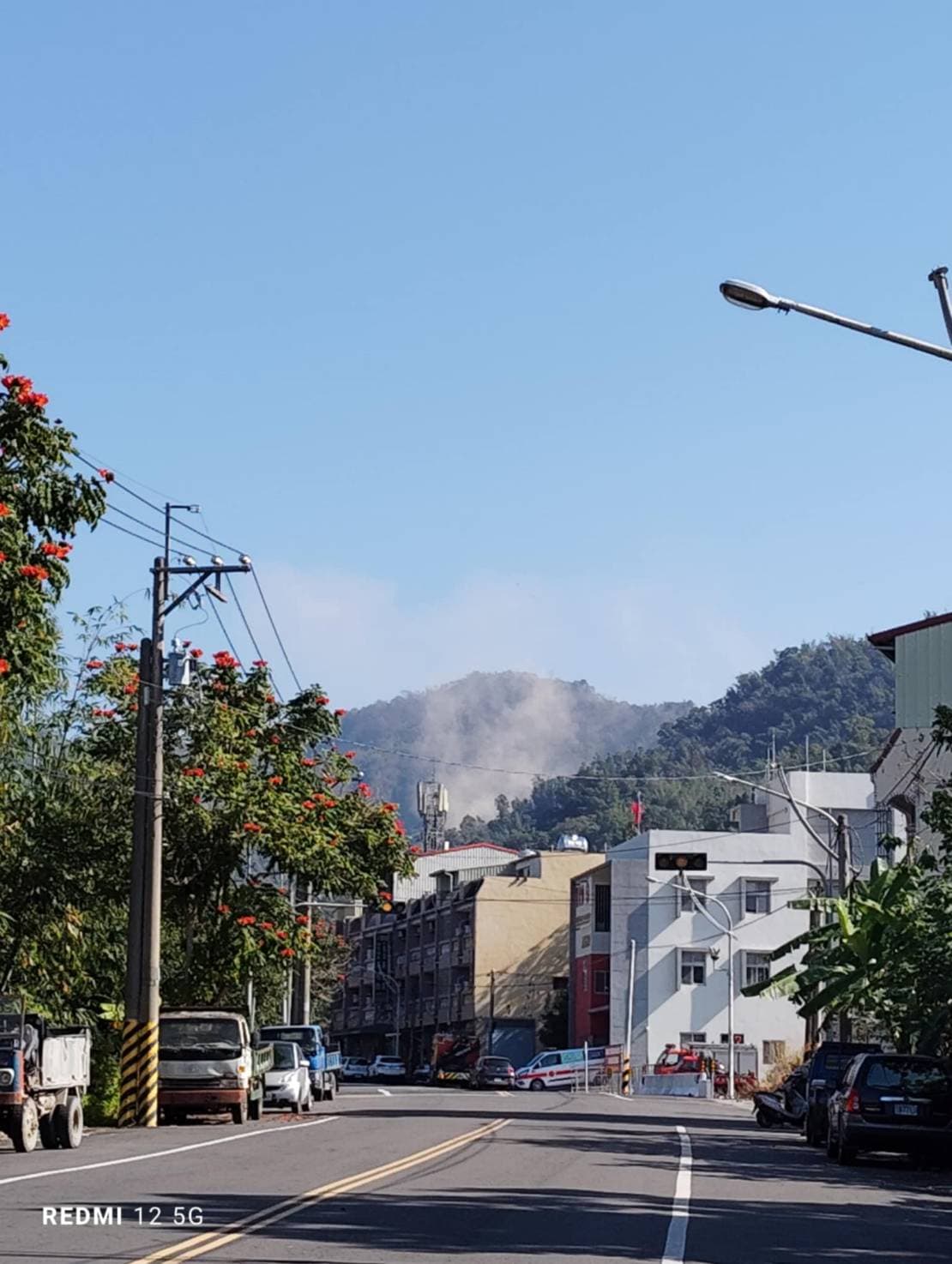大埔市區土石滑落,遠處可見煙霧。(讀者提供)