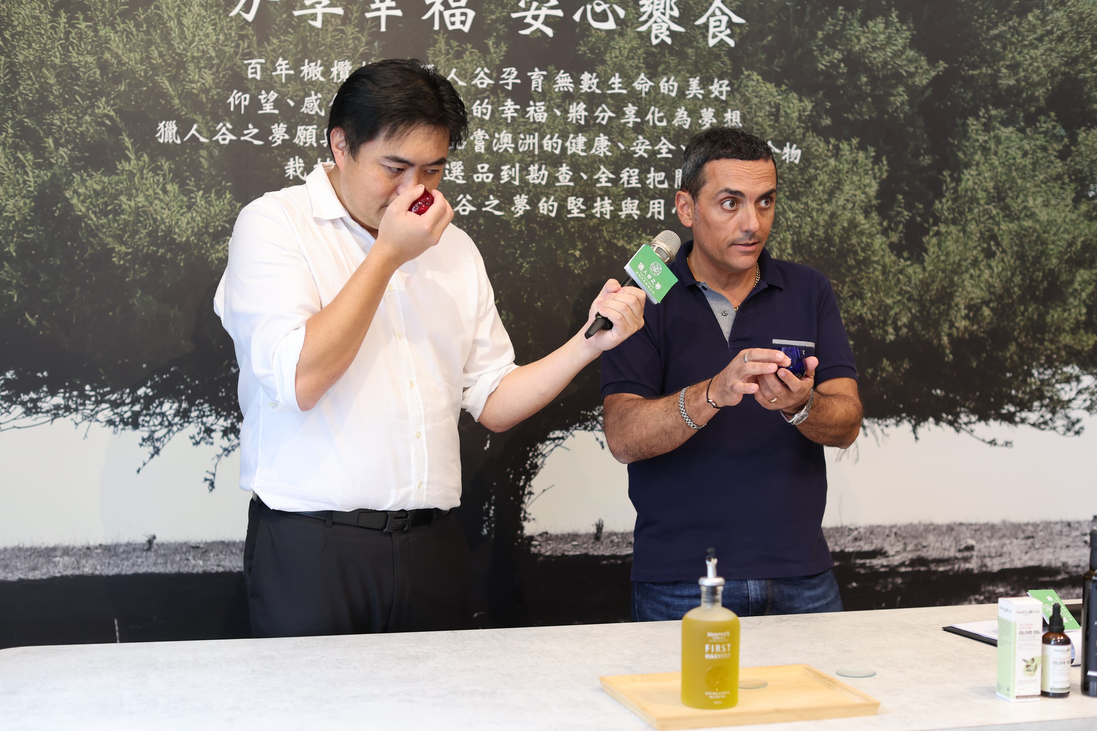 澳洲希爾斯頓的橄欖農莊莊園主人Mauro專程來台教學品油,第一步就是先搓後聞,左為獵人谷之夢執行長Michael。(獵人谷之夢提供)